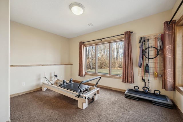 exercise room with carpet and baseboards