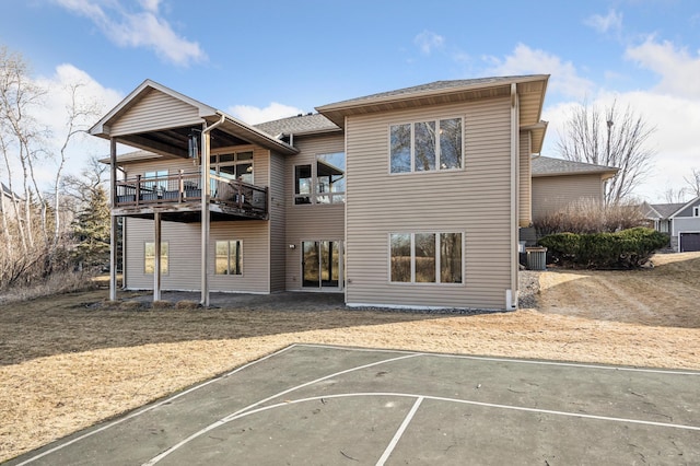 back of property featuring uncovered parking and basketball court