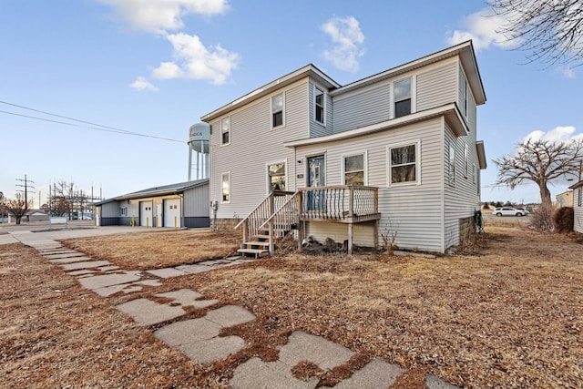 rear view of house featuring a wooden deck