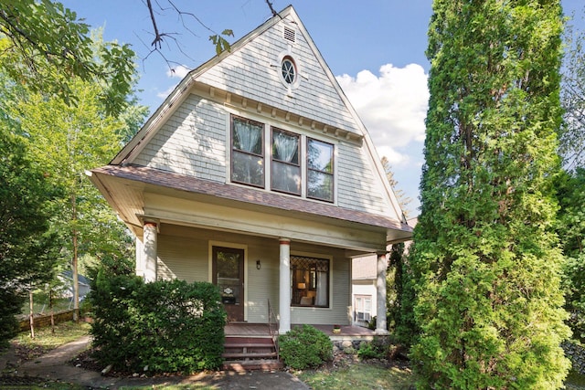 view of front of house featuring a porch, roof with shingles, and a gambrel roof