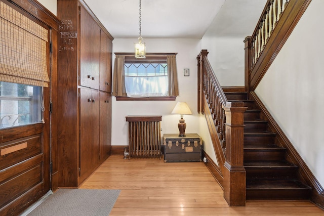 interior space featuring radiator heating unit, wood finished floors, and baseboards