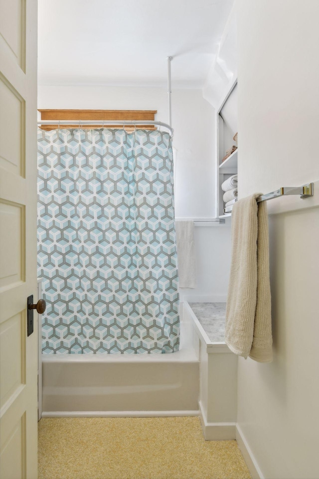 bathroom featuring baseboards and shower / bath combo with shower curtain