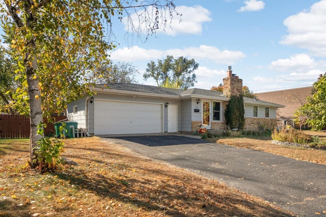 ranch-style house with a garage, driveway, a chimney, and fence