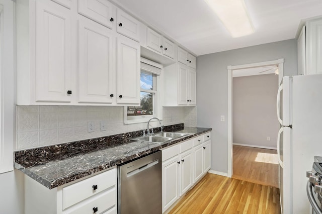 kitchen with stainless steel appliances, a sink, white cabinets, light wood-type flooring, and decorative backsplash