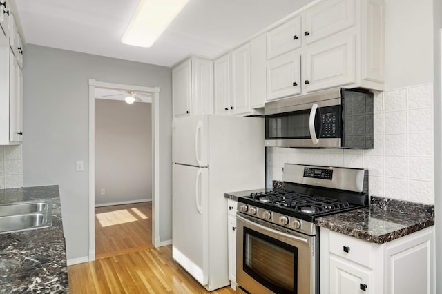 kitchen featuring stainless steel appliances, light wood-type flooring, white cabinetry, and a sink