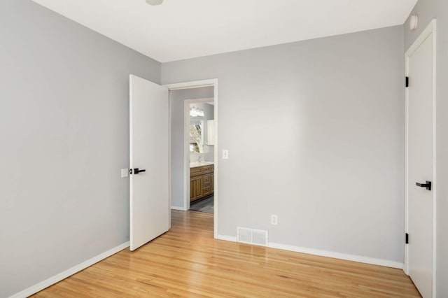 unfurnished bedroom with light wood-type flooring, visible vents, and baseboards