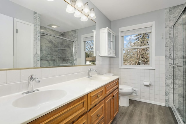 full bathroom with a stall shower, a sink, and tile walls