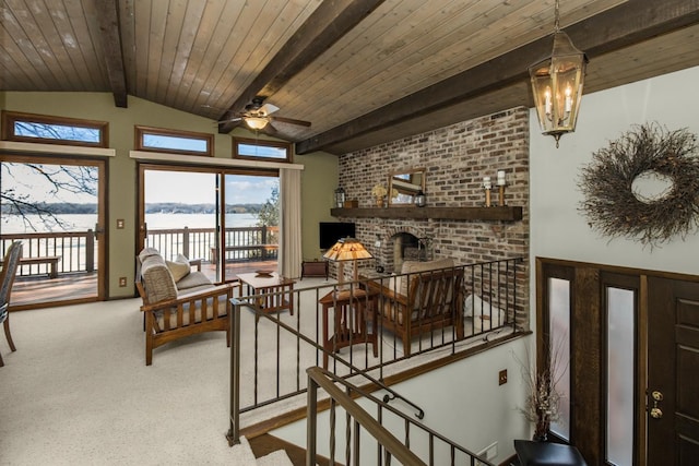 interior space featuring lofted ceiling with beams, stairway, ceiling fan with notable chandelier, and wooden ceiling