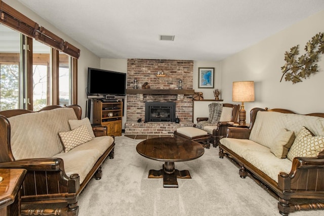 living area with carpet floors, a brick fireplace, and visible vents