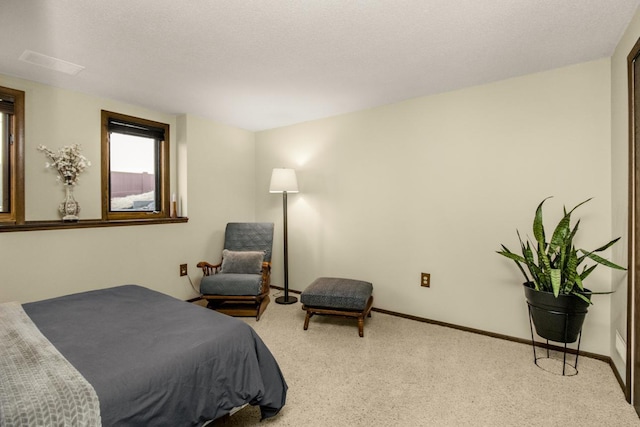 carpeted bedroom with a textured ceiling and baseboards