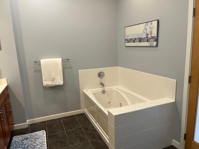 full bath featuring baseboards, a jetted tub, vanity, and tile patterned floors