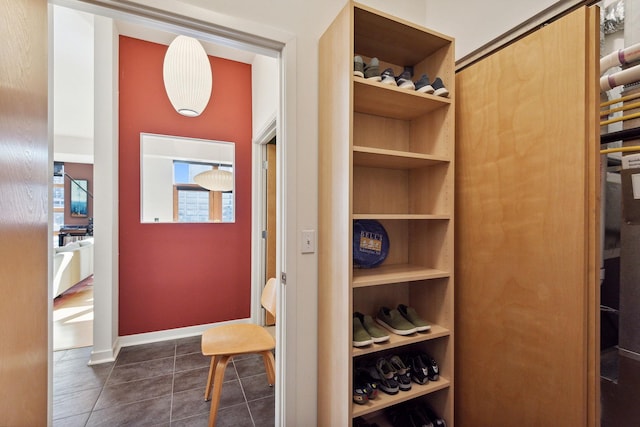 interior space featuring dark tile patterned floors and baseboards