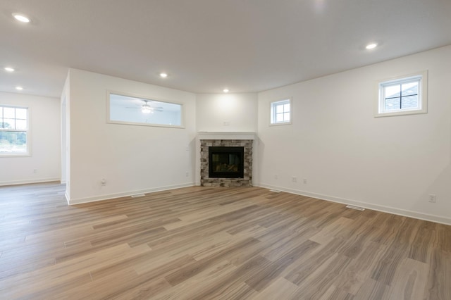 unfurnished living room featuring light wood-type flooring, a fireplace, and recessed lighting