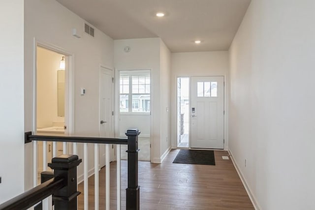 foyer entrance featuring recessed lighting, visible vents, baseboards, and wood finished floors