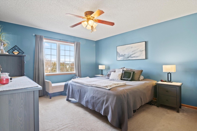 bedroom with a textured ceiling, ceiling fan, baseboards, and light colored carpet