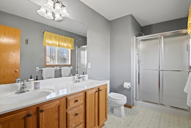 bathroom with a sink, a shower stall, toilet, and double vanity