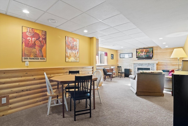 dining space featuring rustic walls, a fireplace, carpet flooring, and recessed lighting