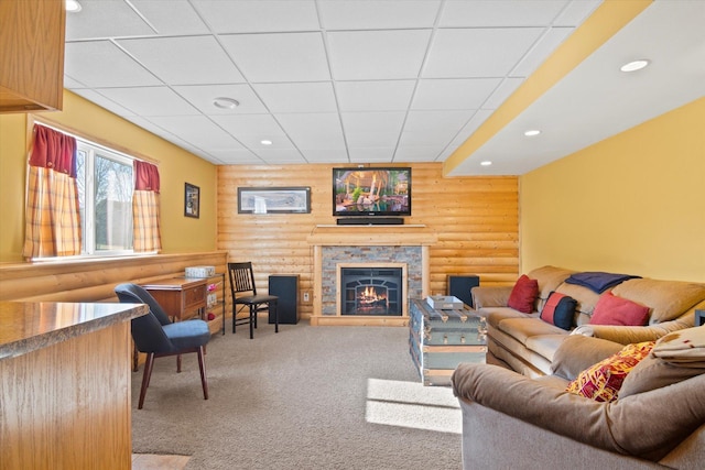 living room with rustic walls, carpet, a fireplace, and recessed lighting