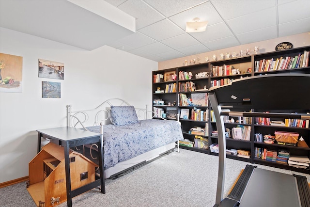 bedroom with carpet floors, baseboards, and a paneled ceiling