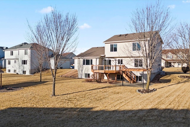 back of property with a yard, a deck, and stairs