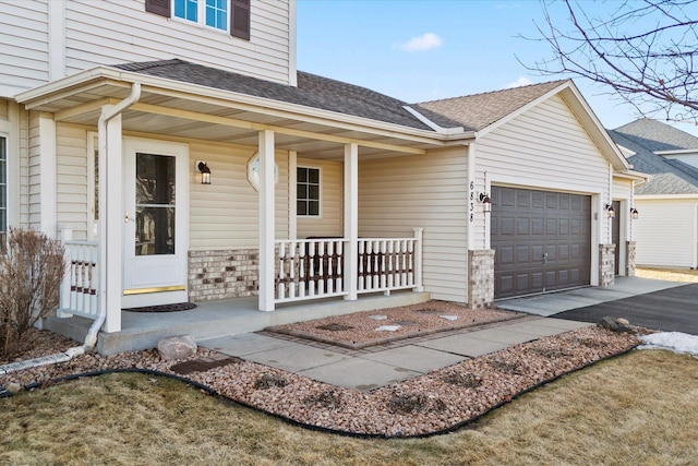 property entrance with a porch, a shingled roof, an attached garage, stone siding, and driveway