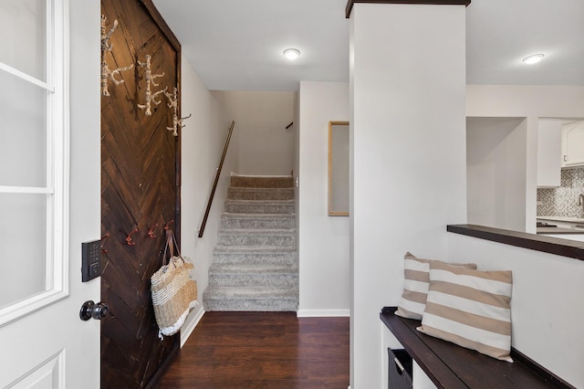 stairs with wood finished floors and baseboards