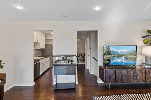 kitchen featuring decorative backsplash, appliances with stainless steel finishes, white cabinetry, a sink, and wood finished floors