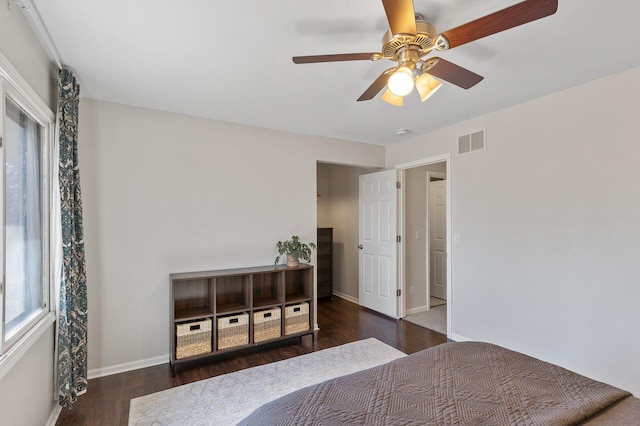 bedroom with a ceiling fan, baseboards, visible vents, and wood finished floors