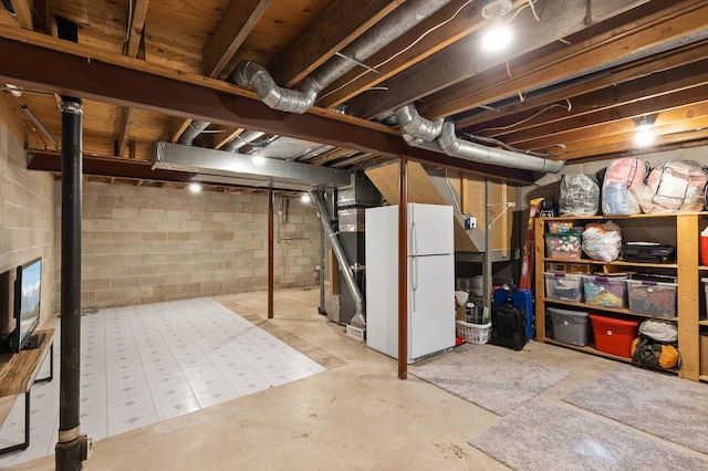 unfinished basement featuring freestanding refrigerator