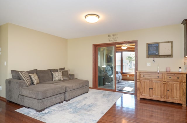 living area with dark wood-style flooring and baseboards