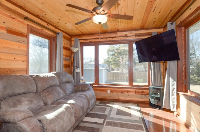 living room featuring wood ceiling, a wood stove, and wooden walls