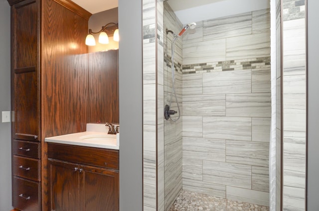 bathroom with tiled shower and vanity