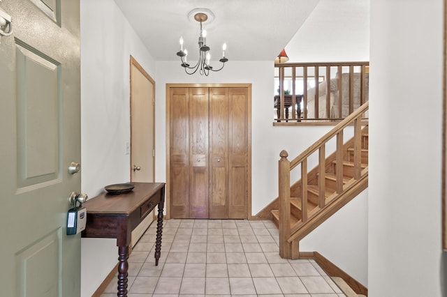 foyer entrance featuring light tile patterned floors, baseboards, and a chandelier