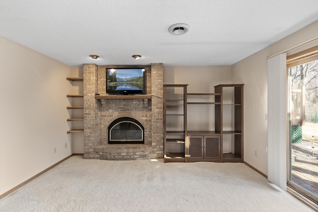 unfurnished living room with a brick fireplace, baseboards, and carpet floors