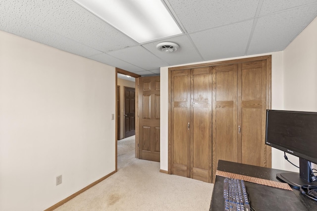 home office featuring a paneled ceiling, baseboards, visible vents, and light carpet