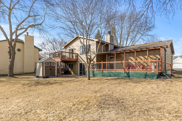 back of property featuring a wooden deck, an outbuilding, a storage shed, and a chimney