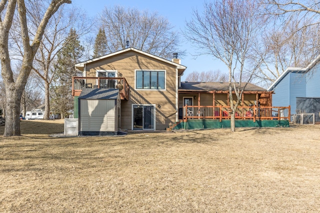 rear view of house with a wooden deck, stairway, a lawn, and a chimney