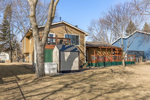 back of house with an outbuilding, a shed, a wooden deck, central AC, and a garage