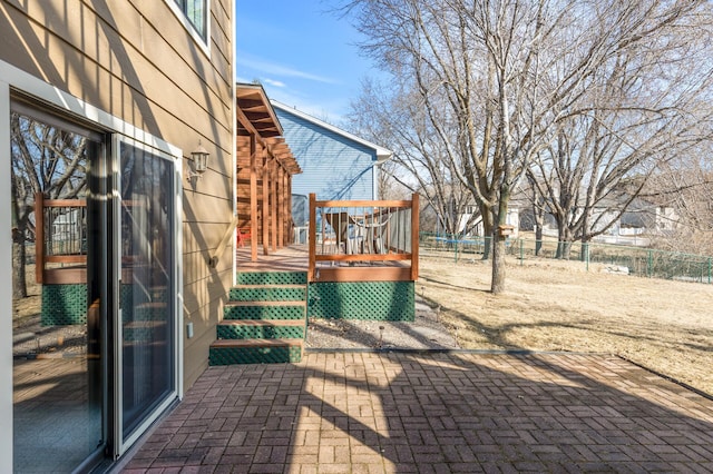 view of patio / terrace featuring a trampoline, a deck, and fence