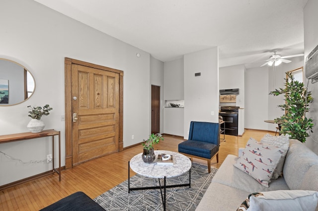 living area with light wood finished floors, ceiling fan, and baseboards