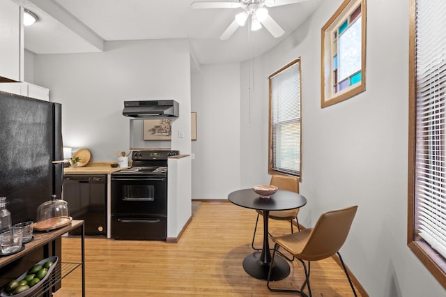 kitchen featuring light wood-style flooring, under cabinet range hood, white cabinetry, baseboards, and black appliances