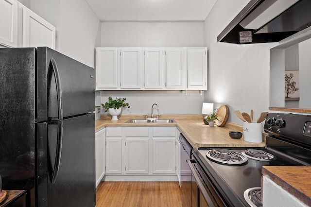 kitchen with black appliances, white cabinetry, and a sink