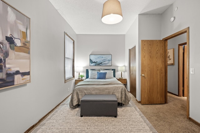 carpeted bedroom featuring baseboards and a textured ceiling