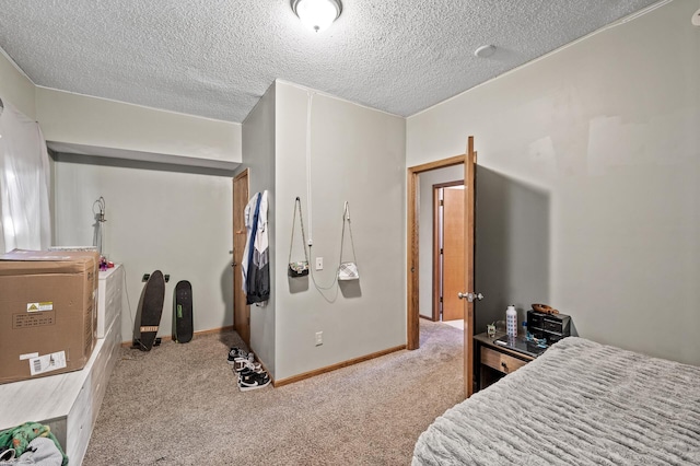 bedroom with a textured ceiling, carpet floors, and baseboards