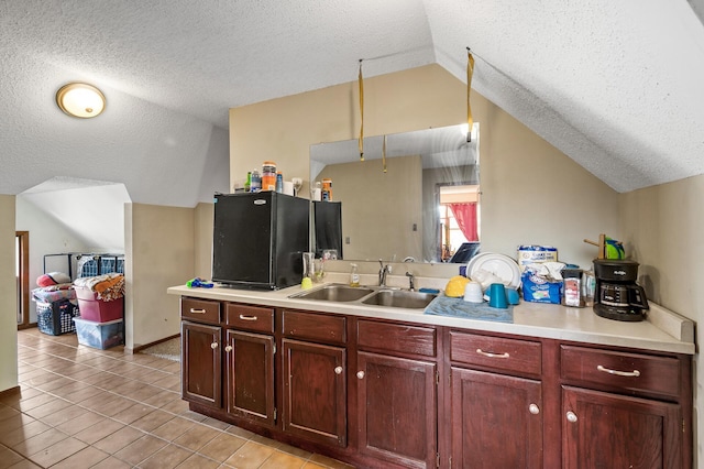 kitchen featuring lofted ceiling, light countertops, and a sink