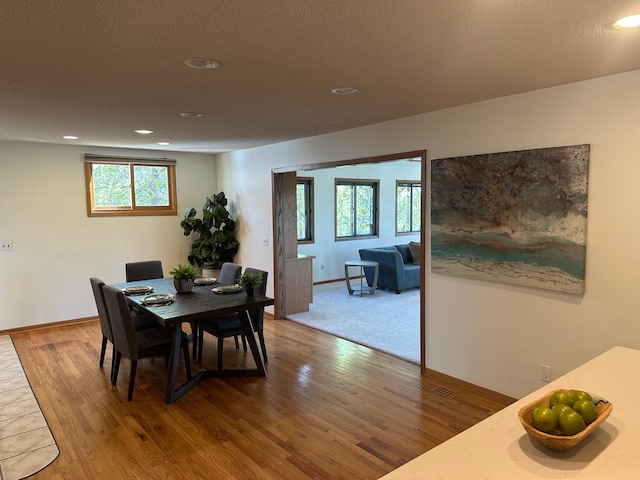 dining space with a healthy amount of sunlight, recessed lighting, and wood finished floors
