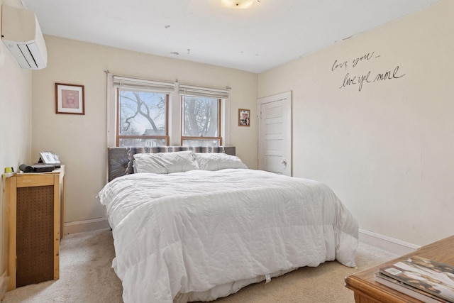 bedroom featuring baseboards, light carpet, and a wall mounted air conditioner