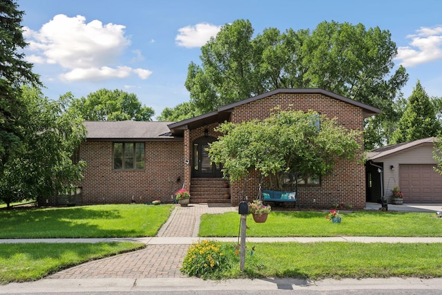 view of front of house with an attached garage, a front lawn, and brick siding