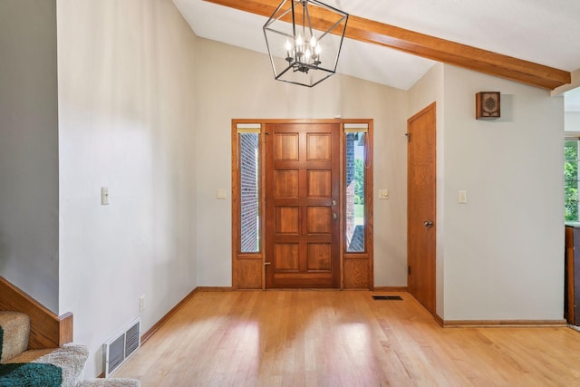 foyer entrance with visible vents, vaulted ceiling with beams, and wood finished floors