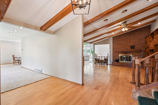 interior space featuring lofted ceiling with beams, wood finished floors, visible vents, and baseboards